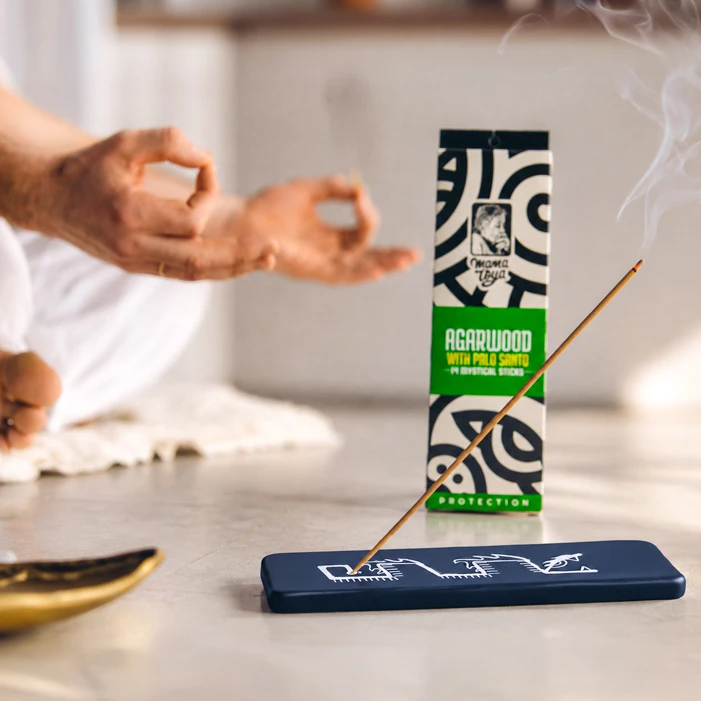 Agarwood with Palo Santo incense stick burning beside a meditation practice