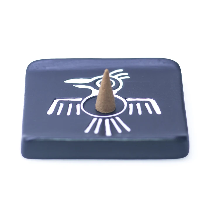 Palo santo incense cone burning on handmade Peruvian ceramic Condor burner
