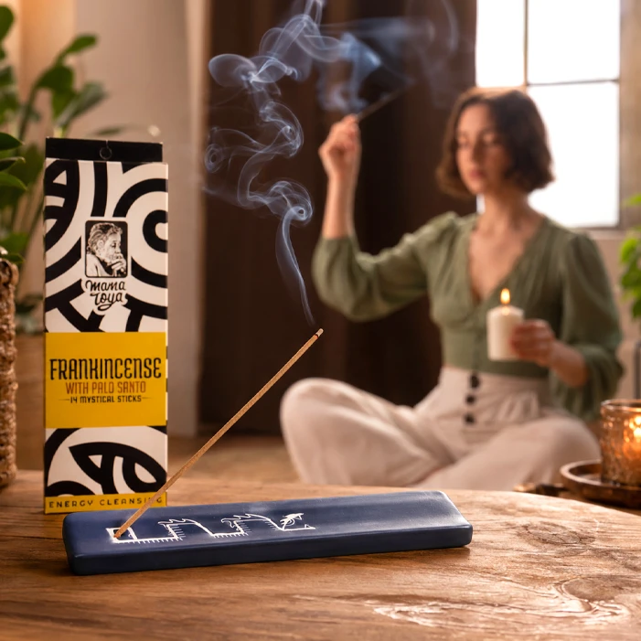 Frankincense with Palo Santo incense stick burning on ceramic holder during a calm cleansing ritual