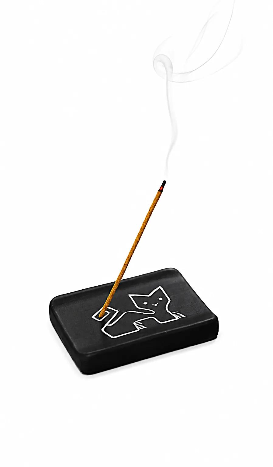 Munay Puma black ceramic incense holder with a lit incense stick, handmade in Peru